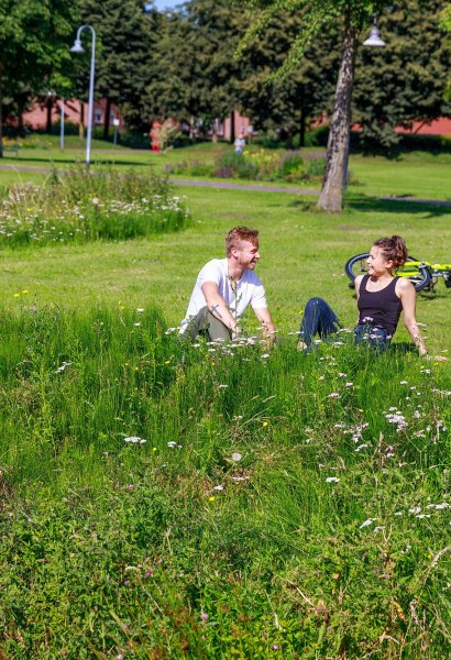 Ein Pärchen sitzt am Ufer im Rasen im Zitadellenpark in Vechta.