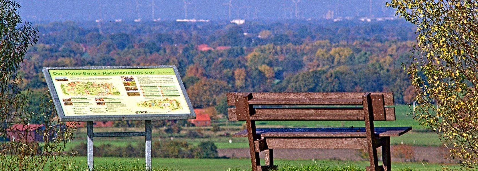 Eine Holzbank bietet Sicht auf das Tal.