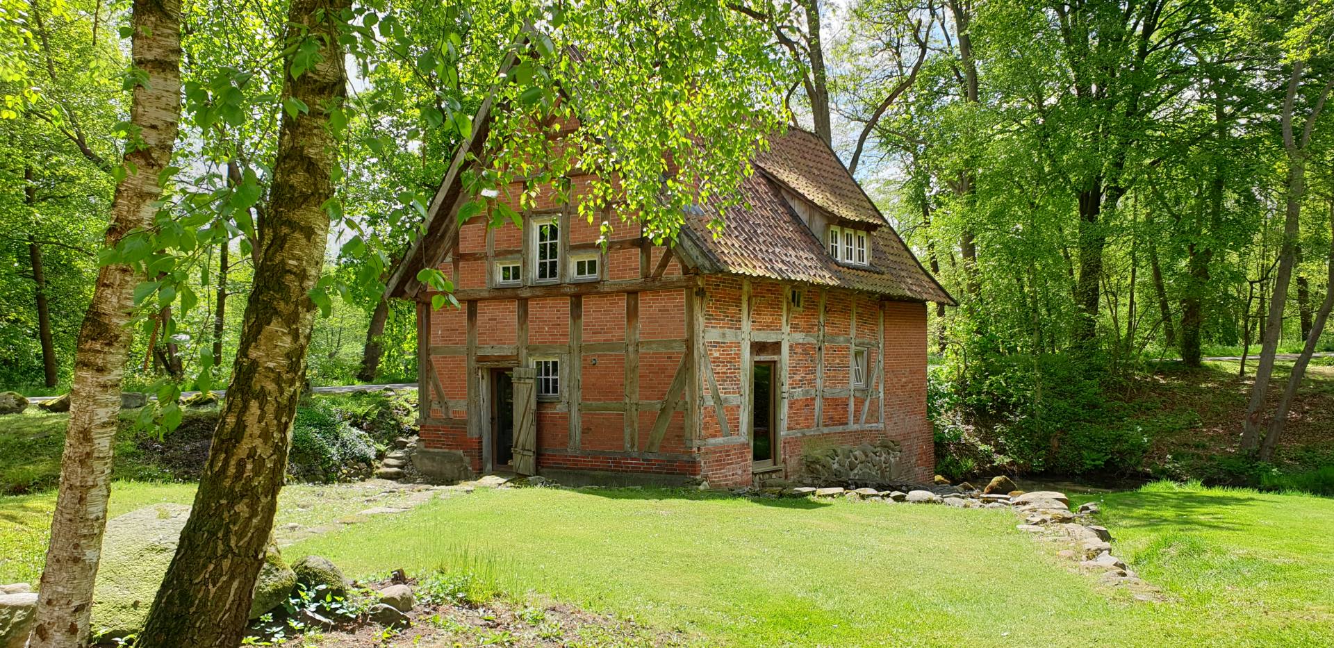 Ein altes Fachwerkhaus befindet sich inmitten der Natur.
