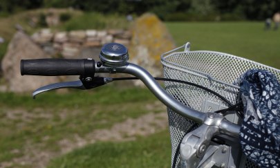 Fahrradlenker und im Hintergrund ein Großsteingrab.